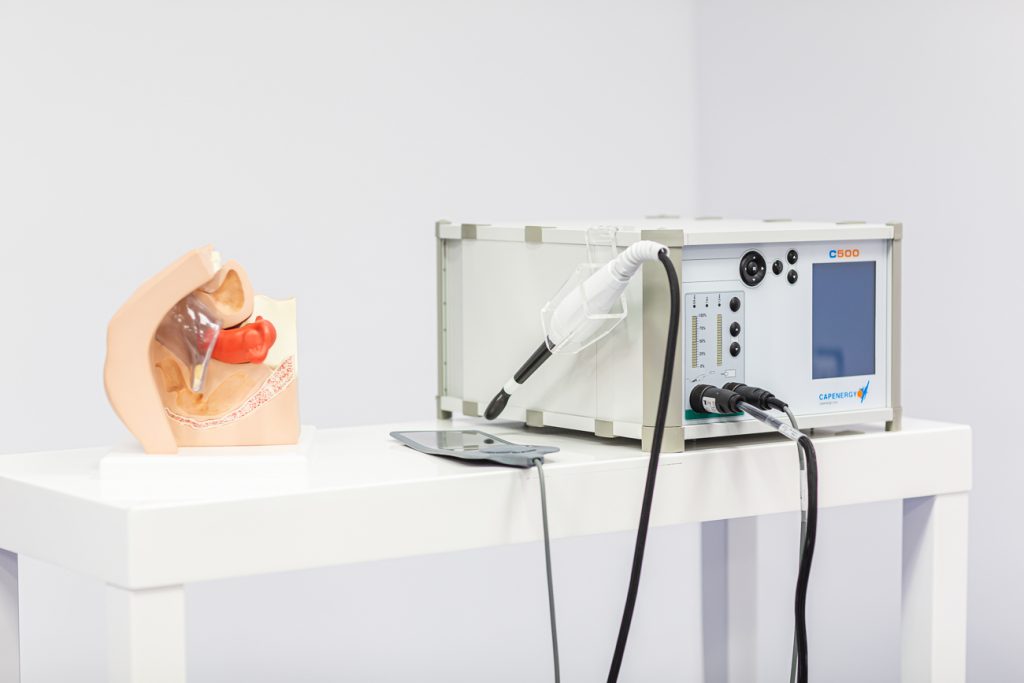Fisioterapeuta explicando el tratamiento de radiofrecuencia TECAR Capenergy para la rehabilitación del suelo pélvico postparto a una paciente